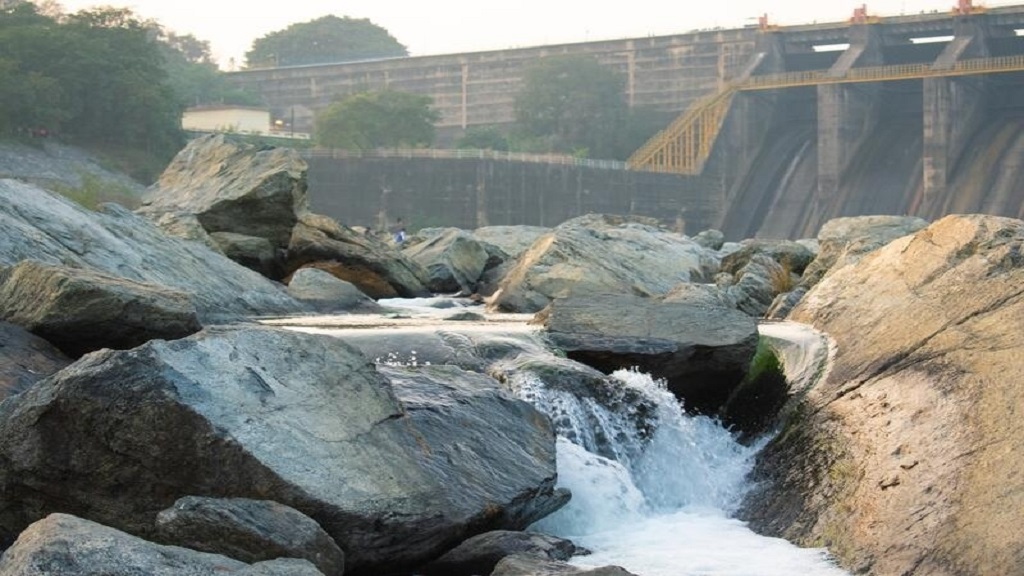 Long stone bridge over a river with lush green surroundings in Purulia countryside
