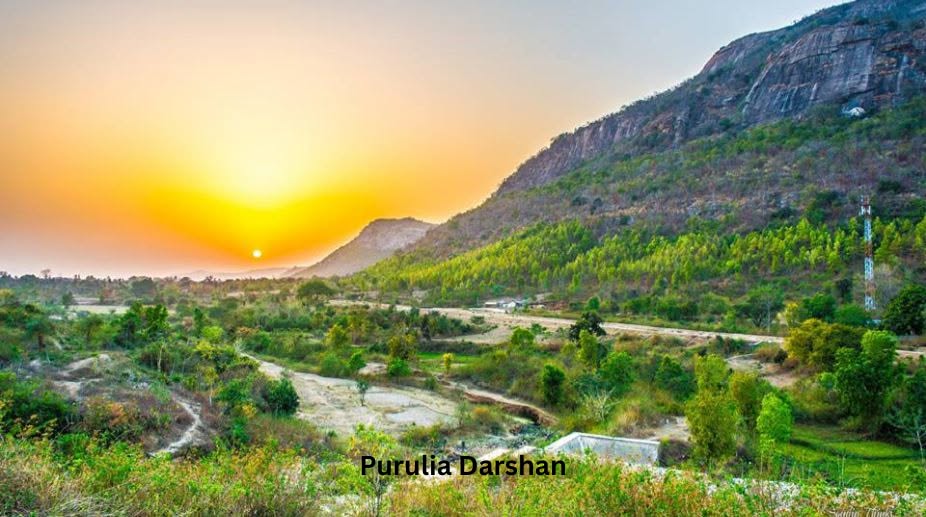 Sunrise over Ajodhya Hills with golden rays illuminating the forest canopy